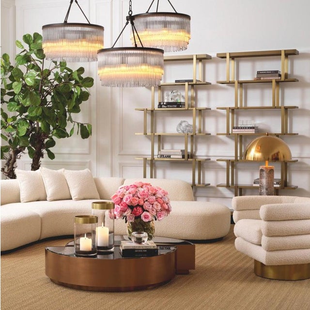 Cabinet in a brushed brass finish, smoked glass, and black glass. Its stepped structure rests on an oak veneer base and...
