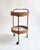 A charming Austrian bar trolley from the 1950s, its black lacquered iron frame carrying two oval woven rattan baskets, the...