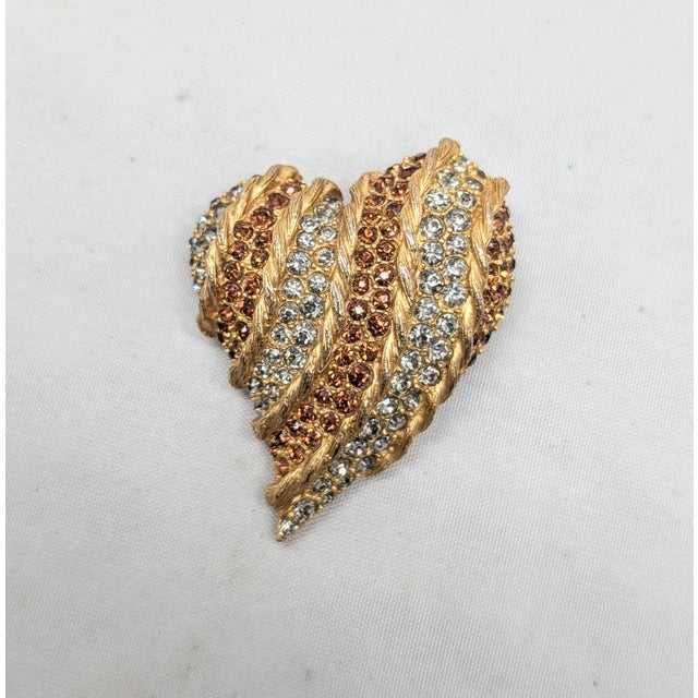 1960s goldtone pavé round faux-topaz and clear rhinestones striped heart brooch with security clasp. Marked "Rifas" in...