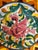 Striking vintage hand-painted majolica-style decorative pottery plate featuring a stylized pink mythical bird or griffin...