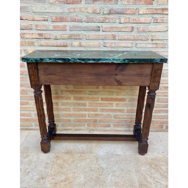 Early 20th century Spanish carved walnut console table with two drawers and green marble top. This early 20th century...