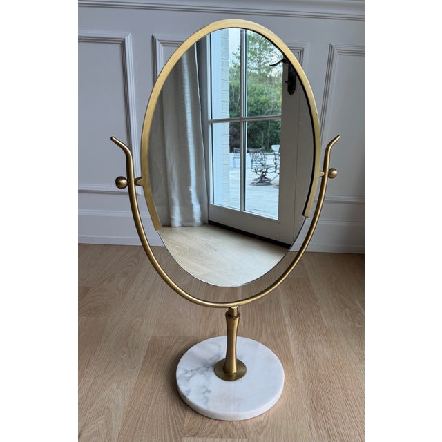 An exceptional and substantial oversized solid brass and Carrara marble vanity mirror attributed to Charles Hollis Jones,...