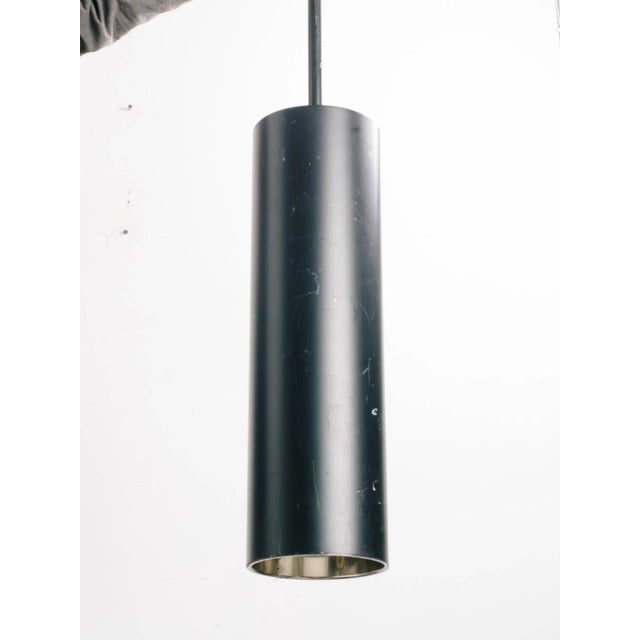 Four 1980s steel tubular pendants. One canopy is missing, finish is scratched in areas.