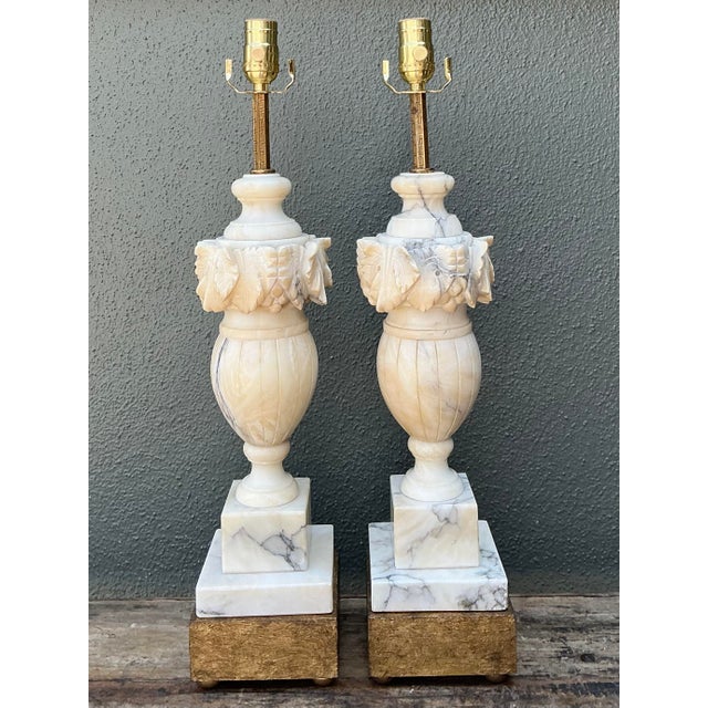 Elevate your interior with this exceptional pair of vintage Neoclassical table lamps, masterfully hand-carved from genuine...