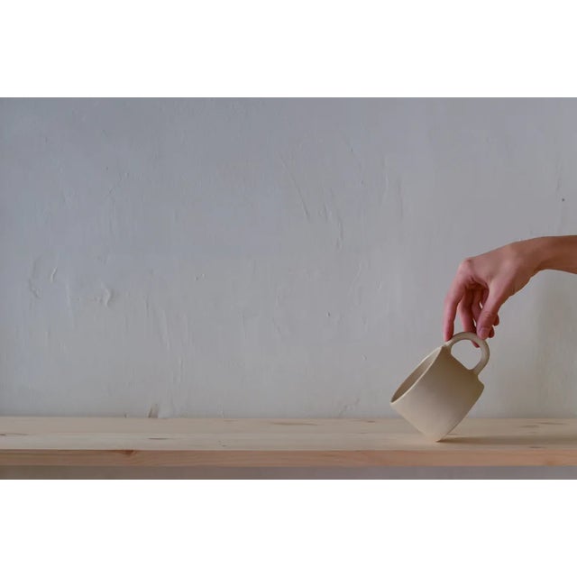 Beige mug from the Kitchen collection. Entirely modeled by hand, enamelled on the inside and bare on the outside....