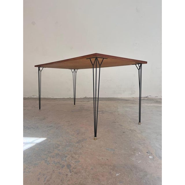 This dining table from the 1960s perfectly embodies mid-century minimalism, captivating with its wonderfully understated,...