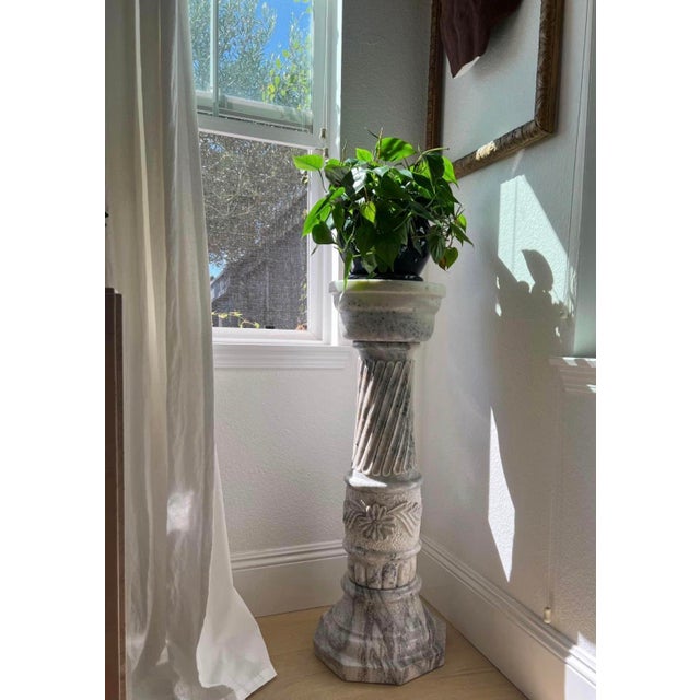Elegant pair of substantial solid marble pedestals featuring beautifully carved spiral-fluted columns, intricate floral...