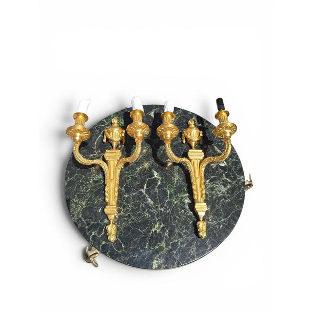 Elegant pair of French wall sconces crafted in finely chased gilt bronze during the early 20th century. Richly ornamented...