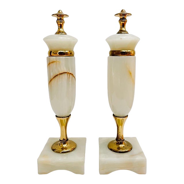 Slender and elegant pair of mid-century French solid onyx urns in a beautiful natural alabaster stone color with veining....