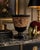 An elegant antique Bohemian amethyst glass footed bowl dating to the early 20th century, featuring a richly detailed gilt...
