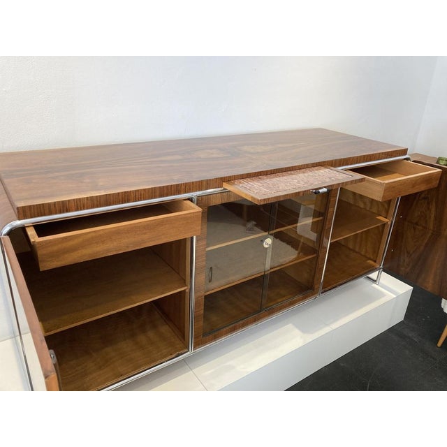 This large walnut veneered sideboard has been repainted and the original chrome -plated steel tube. Polished in the middle...