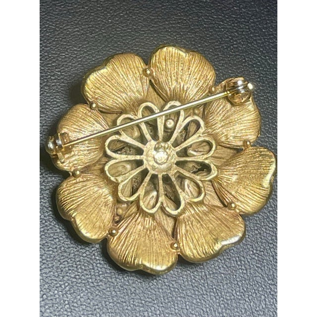MCM dimensional flower brooch by Florenza features a multi-tiered arrangement of cupped, brushed gold-tone petals finished...