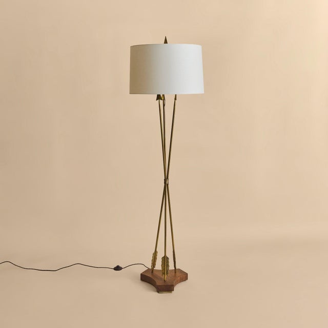A French brass floor lamp by Marcel Guillemard, dating to the 1950s. The design is defined by three slender brass uprights...