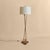 A French brass floor lamp by Marcel Guillemard, dating to the 1950s. The design is defined by three slender brass uprights...
