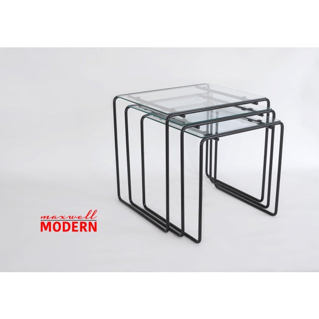 Very rare and super cool vintage set of nesting tables from the 1980s with slim black-painted steel rod frames and...
