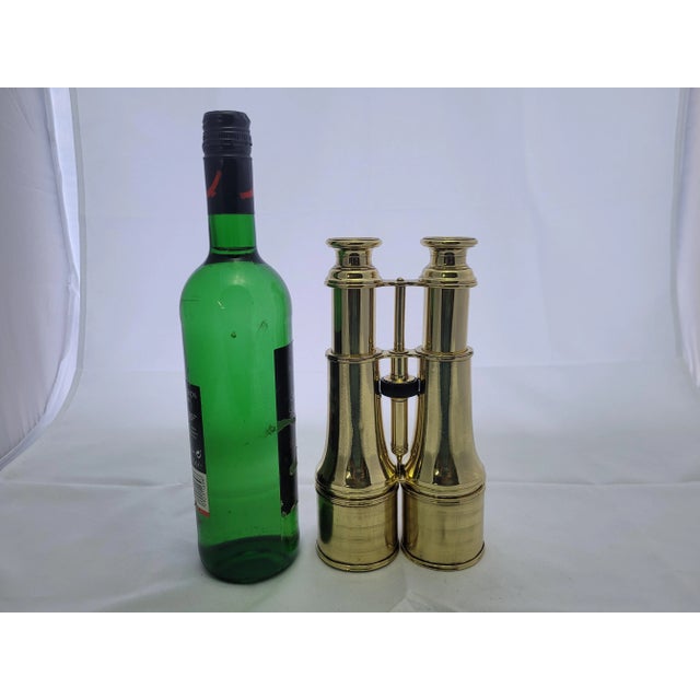 A meticulously polished and lacquered brass binocular with geared focal knob, sunshades, etc. The eye pieces are marked...