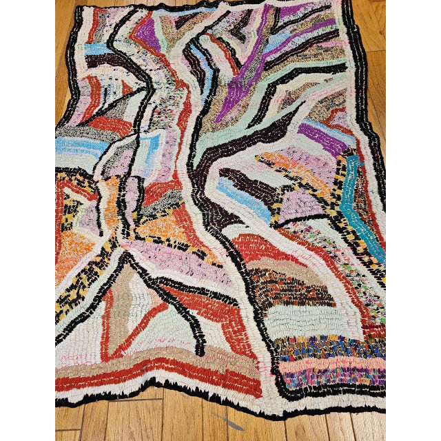 This captivating vintage Moroccan Boucherouite rug is a bold expression of North African textile artistry at its most...