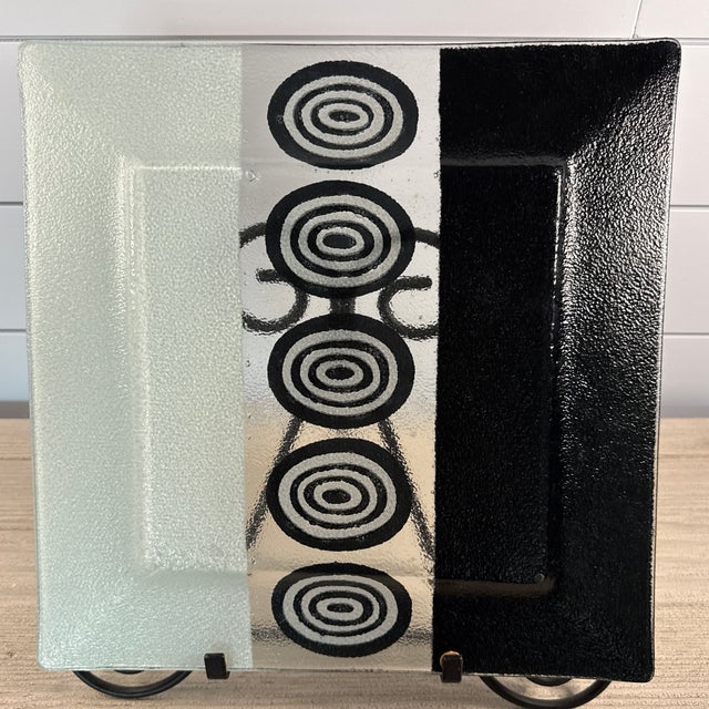 Striking heavy art-glass square platter featuring a bold black-and-white composition with a vertical band of concentric...