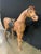 A three feet tall vintage decorative sculptural leather covered horse figure posed standing with its head turned and neck...