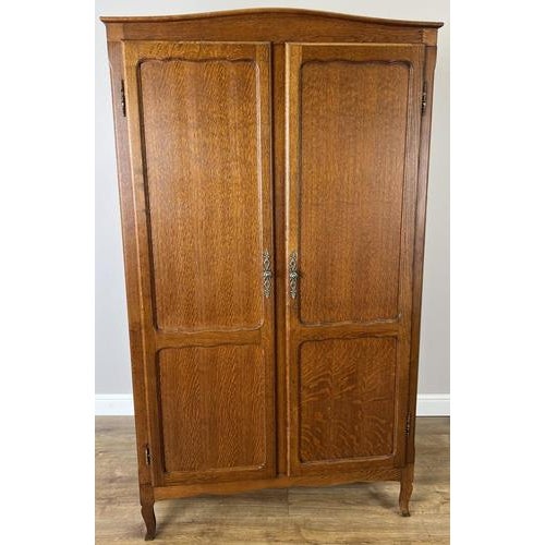 This elegant Vintage French Louis wardrobe displays a beautifully grained oak finish, refined panelled doors, and graceful...