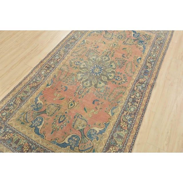 This authentic vintage traditional Tabriz rug is hand-knotted with an all-wool pile on a cotton foundation. This oriental...