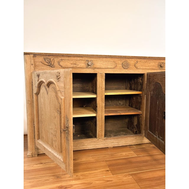 19th Century French Louis XIII style sideboard featuring three intricately carved doors. Constructed from rich, solid wood...