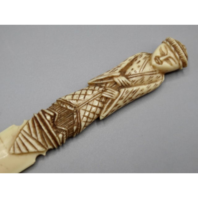A rare, fine quality late 19th-Century Chinese export paper knife handcrafted of carved bone. It depicts an Asian figure...
