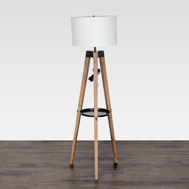 This Pottery Barn floor lamp features a sturdy wooden tripod base with a built-in shelf for added convenience. The lamp...
