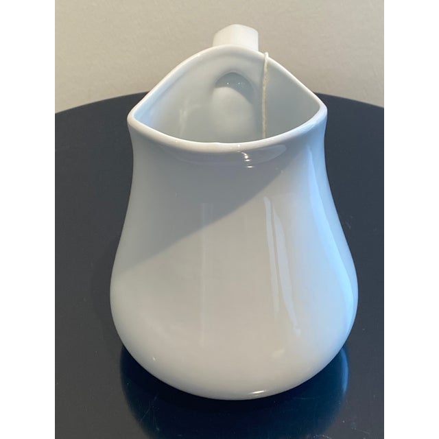 This elegant white ceramic pitcher features a timeless, minimalist design that complements any table setting. Its smooth,...