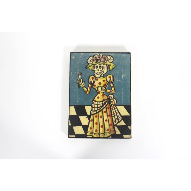 This is a vintage colourful Mexican folk art painting depicting La Calavera Catrina, the iconic dapper skeleton woman...