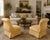 A distinctive pair of circa 1930s–1940s slipper chairs with dramatic scroll-over backs, low armless profiles, tailored...