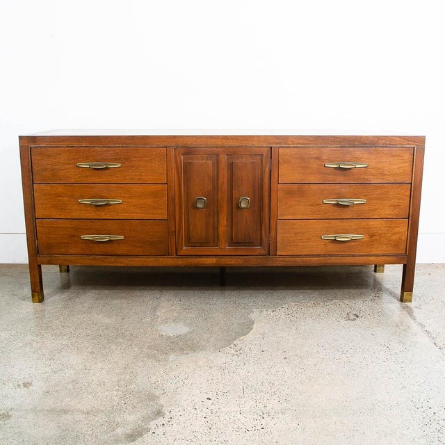 Clean and handsome walnut highboy dresser in walnut by American maker Stanley. Comes with 9 drawers, 2 behind cabinet...