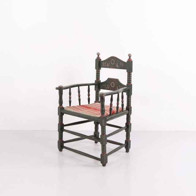 Antique norwegian folk chair in painted wood, dated 1872. The chair features traditional carved and painted decoration...