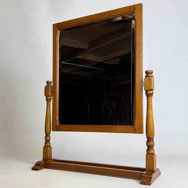 A charming 20th-century English dressing table mirror, finely crafted from oak and distinguished by its compact...