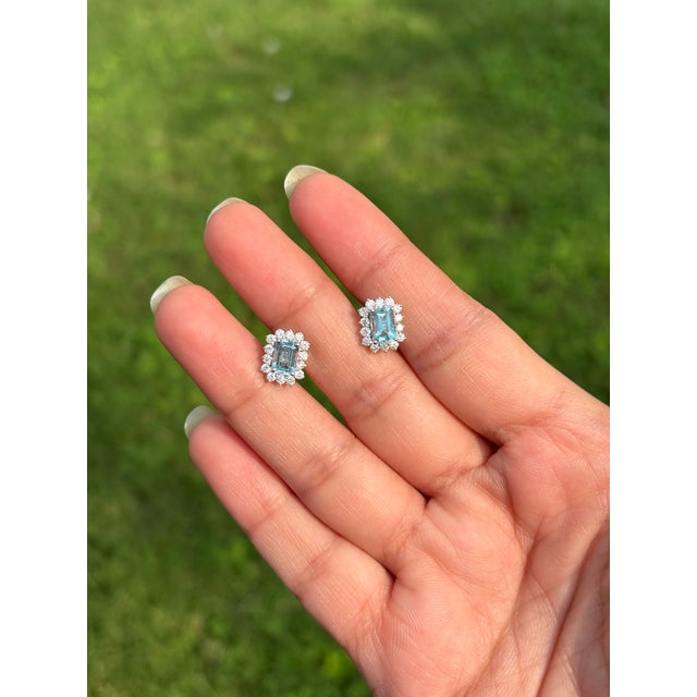 These stud earrings featuring a 1.14 carat emerald-cut aquamarine and diamond, set in 14K white gold. The aquamarines...