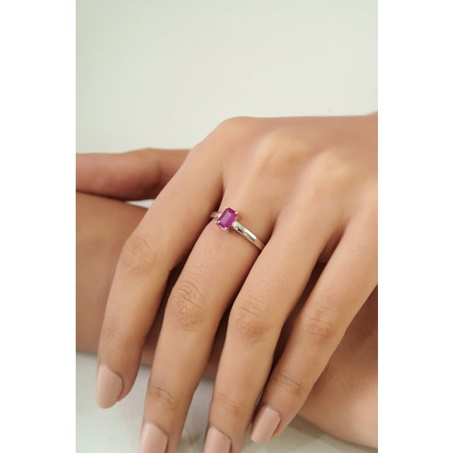 This Dainty 0.69 Ct Octagon Ruby & Diamond Three Stone Ring is crafted in 925 sterling silver, featuring a natural ruby in...