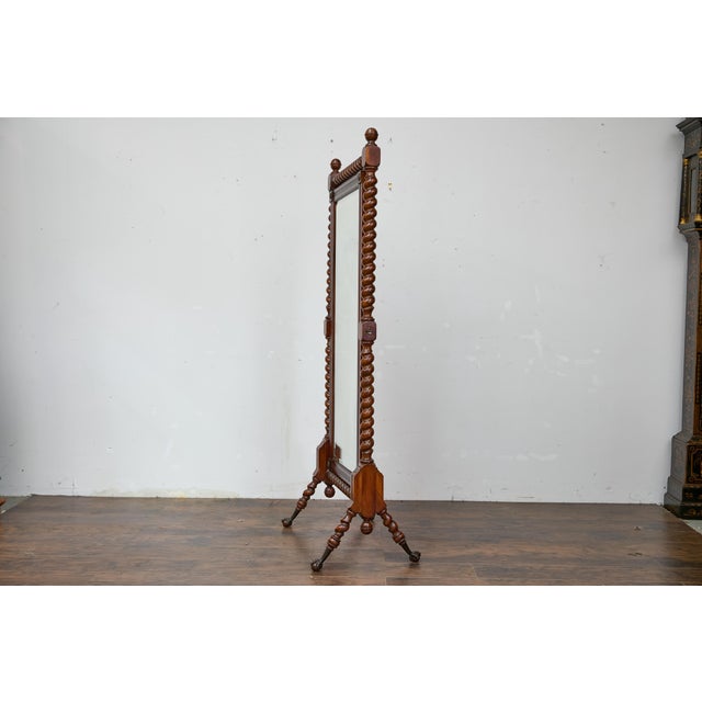 An English full length cheval mirror from the 19th century with barley twist frame and ball and claw feet. This elegant...