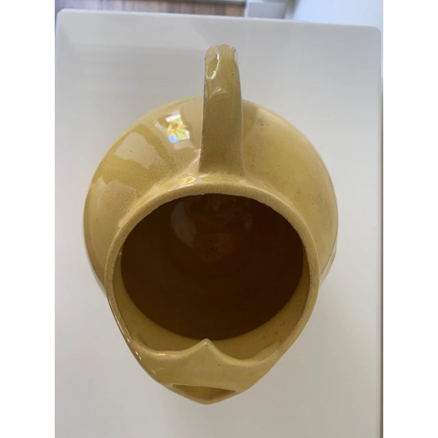 Mid century art deco balloon pottery pitcher in yellow with ice spout in canary yellow.