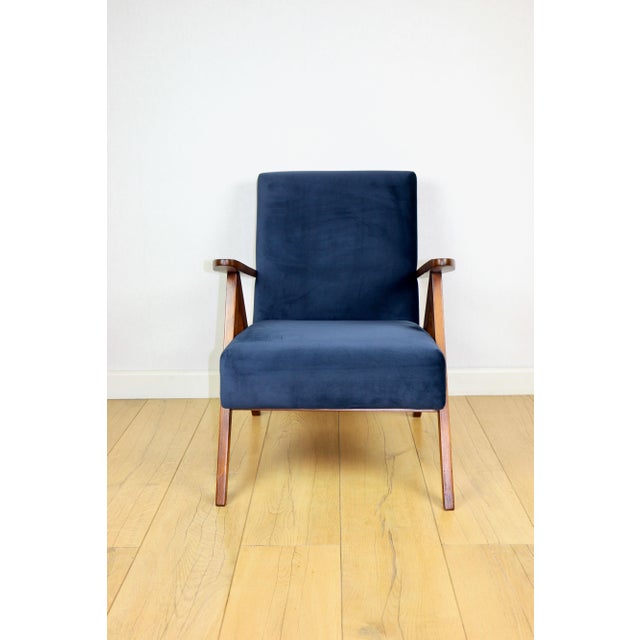 Classic armchair Var B-310 from the 1960s, vintage style, upholstered in navy blue velvet with dark wood elements. We...