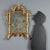 Carved and gilded wood mirror, featuring a molded frame that highlights elegant foliate carvings and scrolls. The mercury...