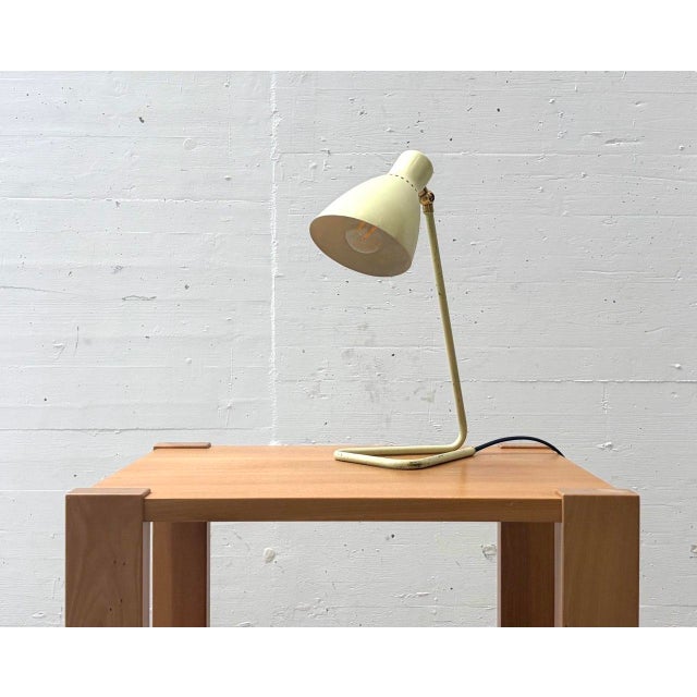 A distinctive table lamp by french designer robert caillat from the 1950s. The slender metal frame flows into a gently...