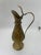 A charming brass pitcher adorned with intricate flower details and a gracefully curved handle. This elegant piece exudes...