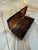 A long, rectangular box crafted from lucite finished in a rich faux-tortoiseshell pattern, with mottled tones of amber,...