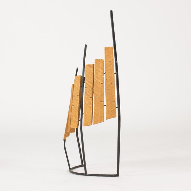Beautiful sculpture by Fred Leyman, made with wood arranged on a black lacquered metal frame that is arched in the base....