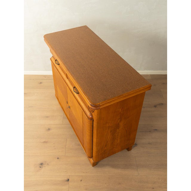 A wonderful Art Deco chest of drawers from the 1920s. High-quality ash veneer frame with two doors, one shelf, two...