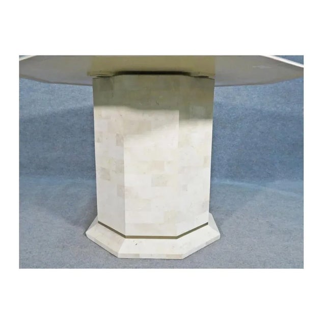 With a tessellated stone surface and brass inlay, this large dining table is unique and impressive.