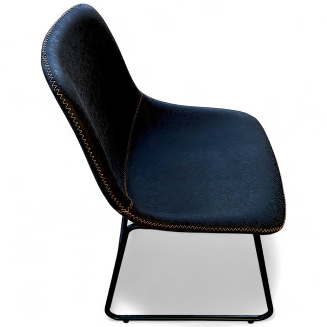 A set of four contemporary contoured formed foam bucket seat style dining chairs upholstered in slightly distressed...