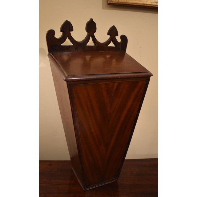 Wall box for pipes, 19th century, walnut. A swagged pierced crest rail is above a sloped lid with a thumbnail molded edge....