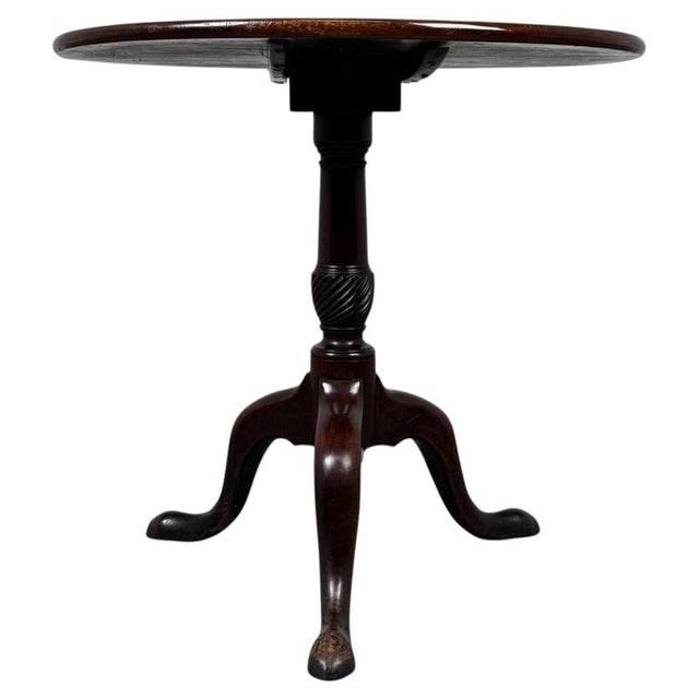 A refined 18th-century English Georgian tilt-top table, finely crafted from mahogany and distinguished by its elegant...
