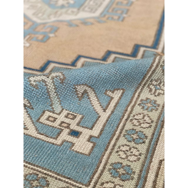 A lovely vintage Oushak rug. This Turkish Oushak offers a beige and blue palette with tan and wheat accents.